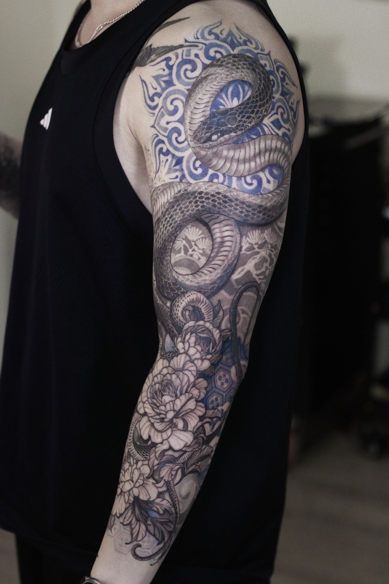 Black and blue snake floral sleeve tattoo by Hoang Bao at Overthink-Ink Saigon